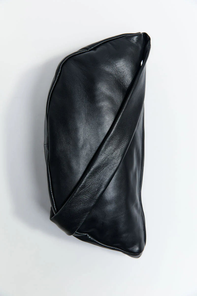 Black leather crescent shaped bag on a white background