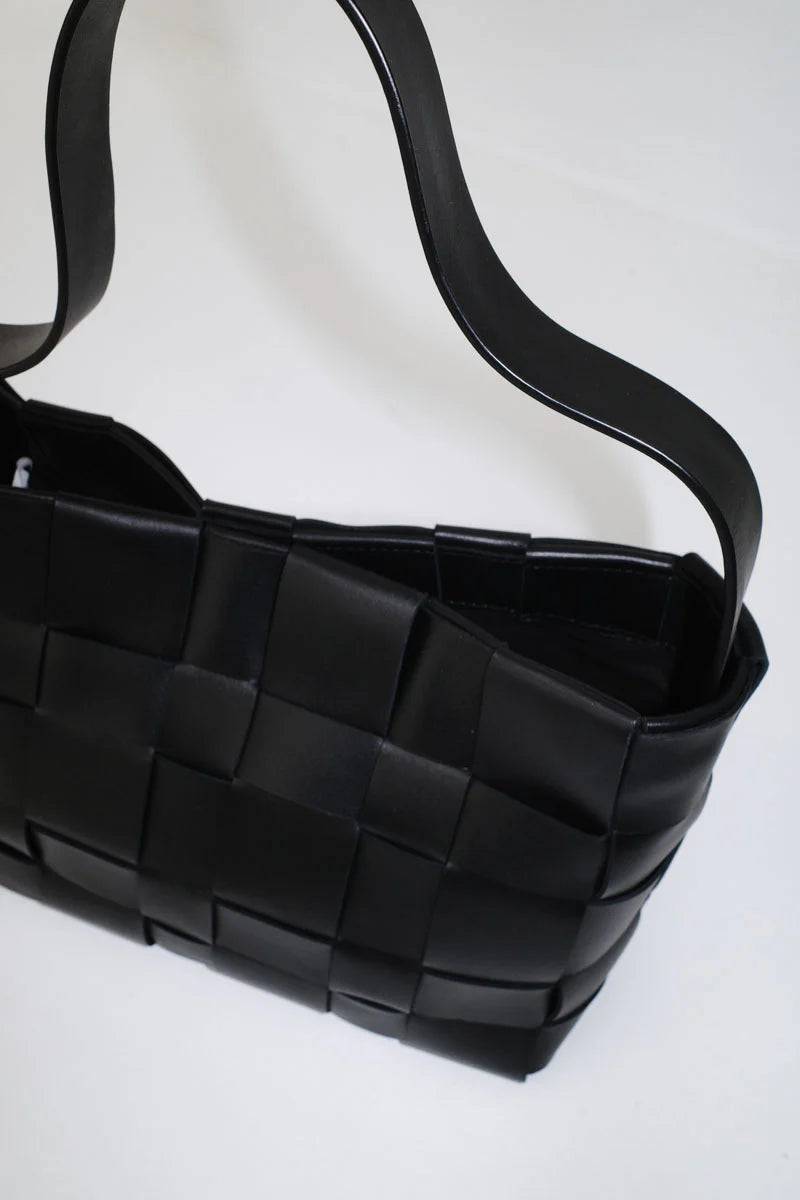 Black woven handbag on a white background