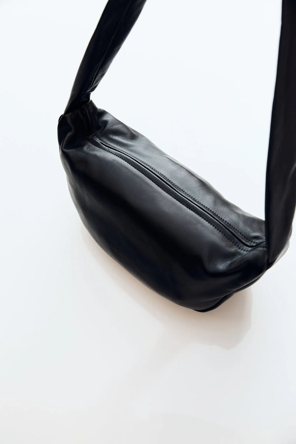 Black leather crossbody bag on a white background