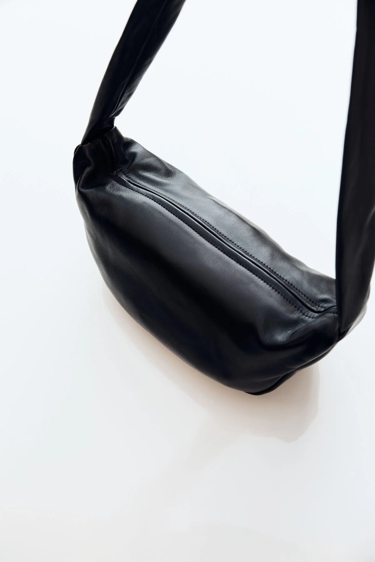 Black leather crossbody bag on a white background