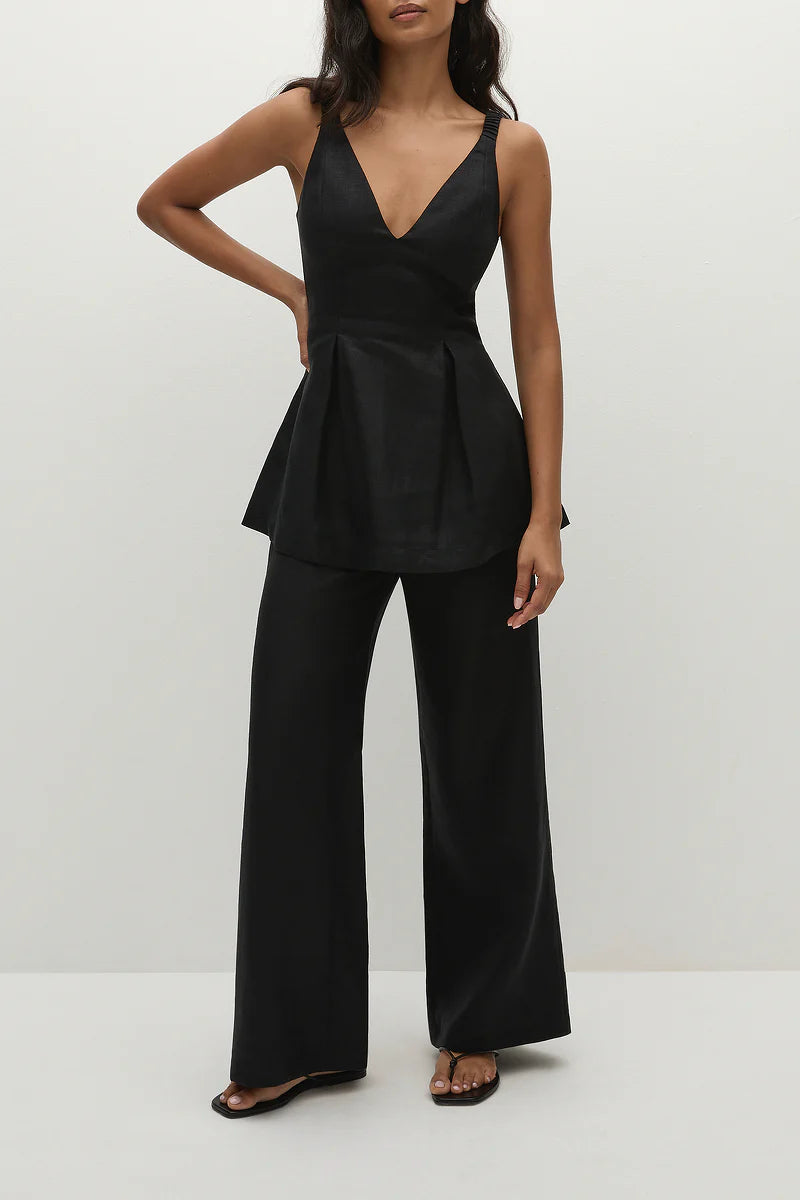 Woman wearing black linen trouser pants on white background