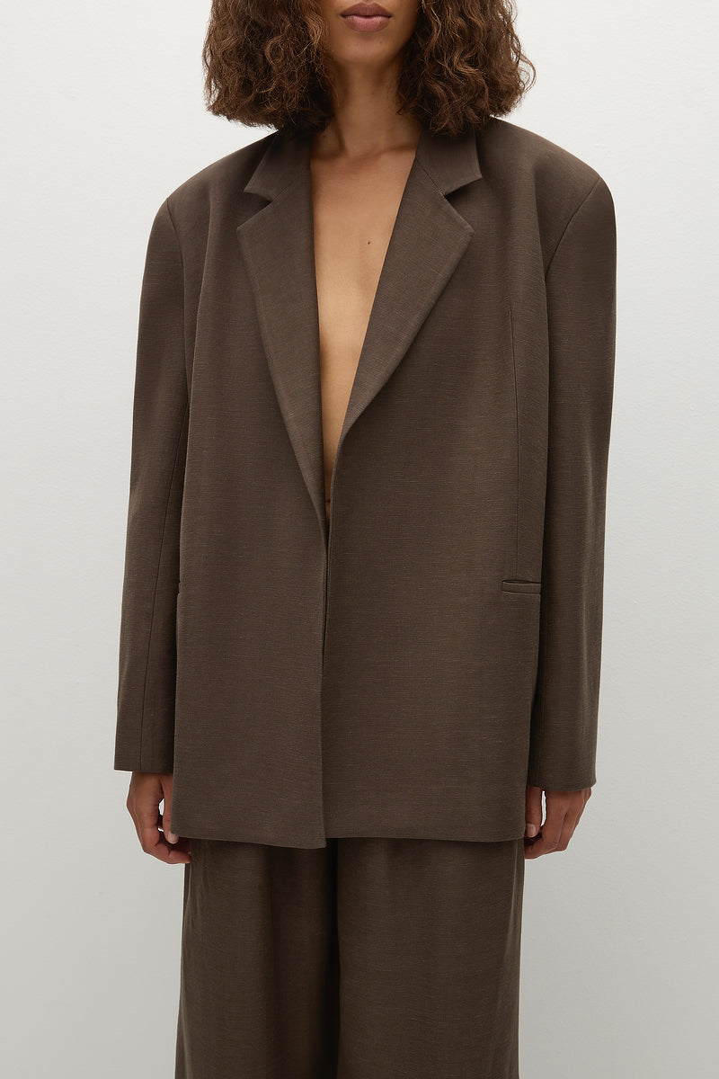 Model wearing sustainable brown linen suit jacket