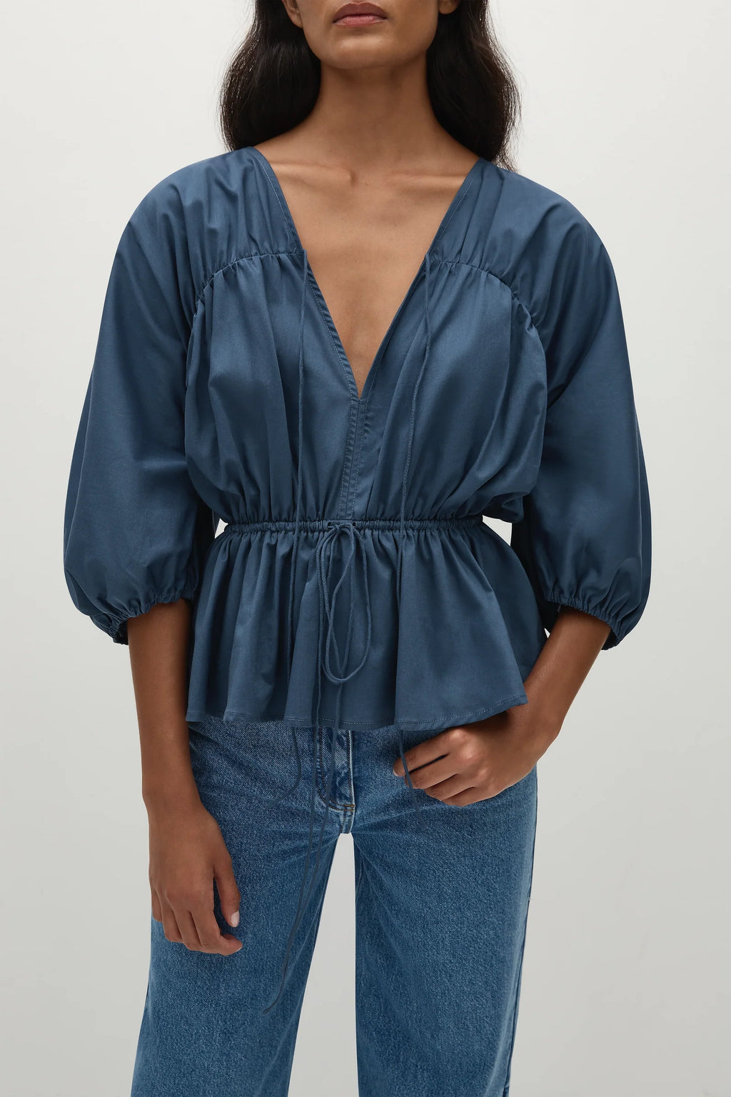 woman wearing a romantic style vintage blue blouse with puff sleeves and a cinched waist