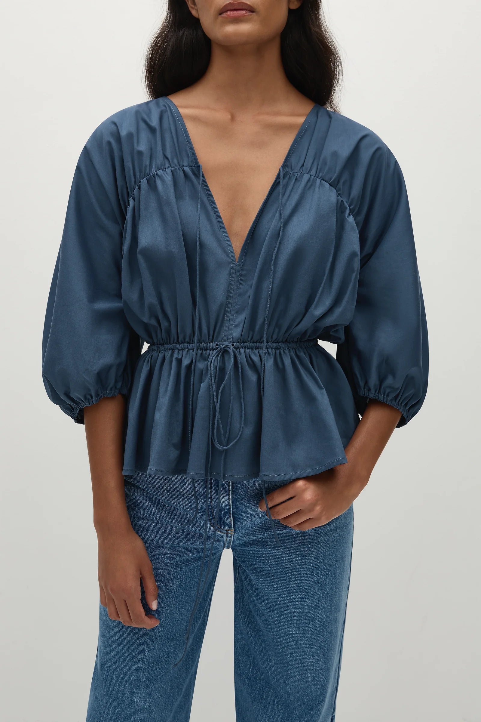 woman wearing a romantic style vintage blue blouse with puff sleeves and a cinched waist