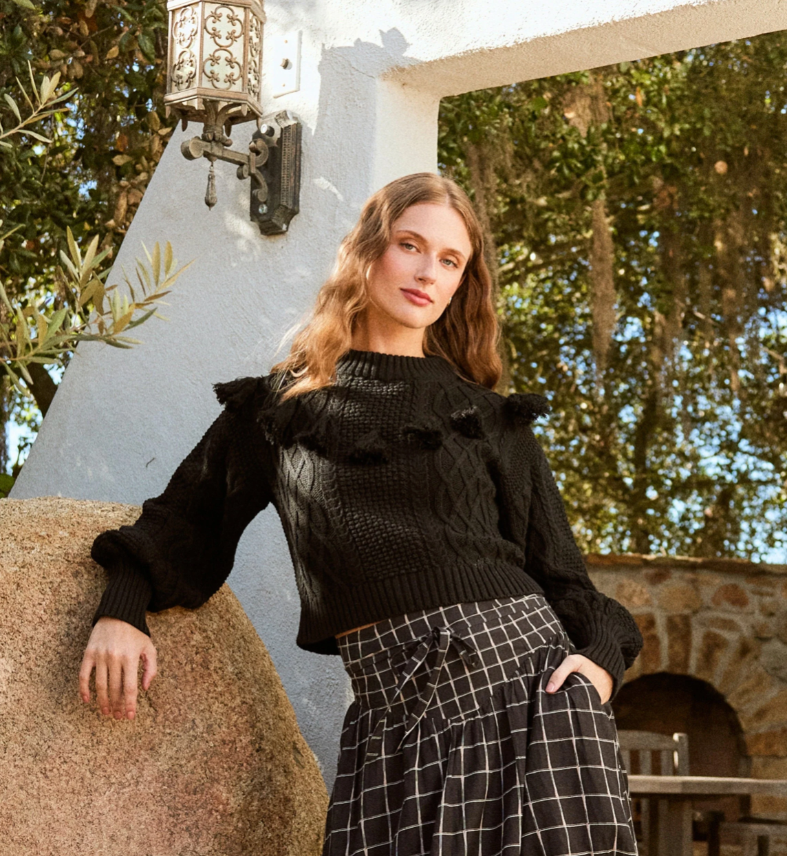 Woman wearing sustainable black sweater made from organic cotton, styled with casual fall outfit.