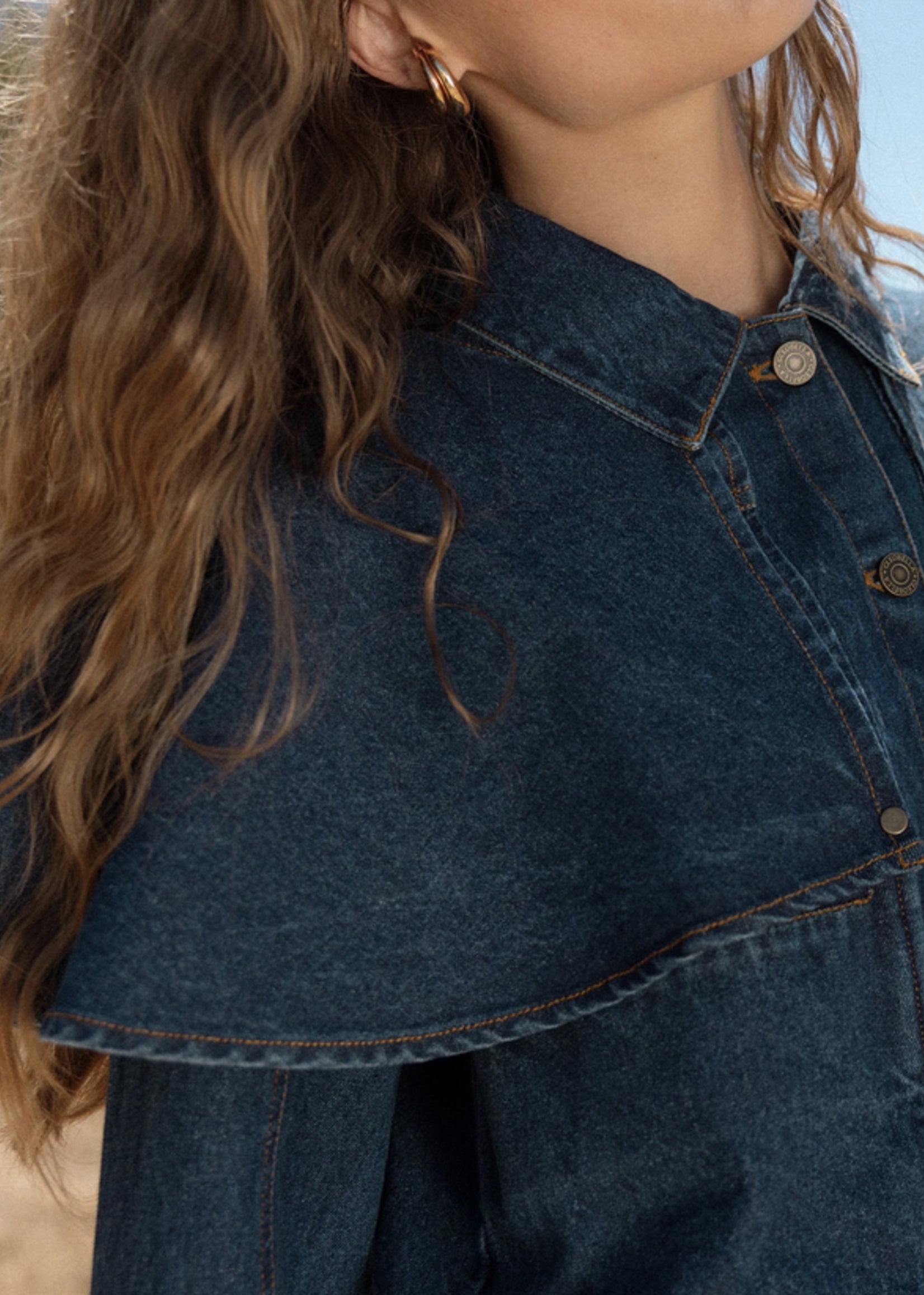 Person wearing a dark denim jacket with a blurred background