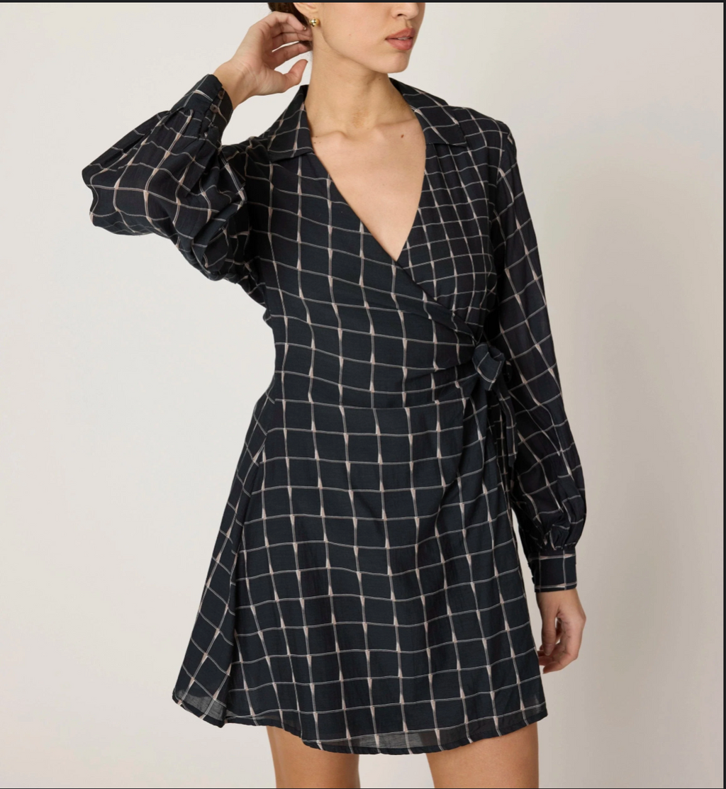 long sleeve wrap dress in Black and white checkered pattern worn by a model on a plain background